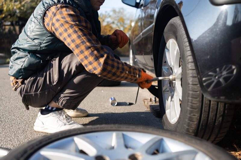 prikaz momka koji menja gumu na automobilu