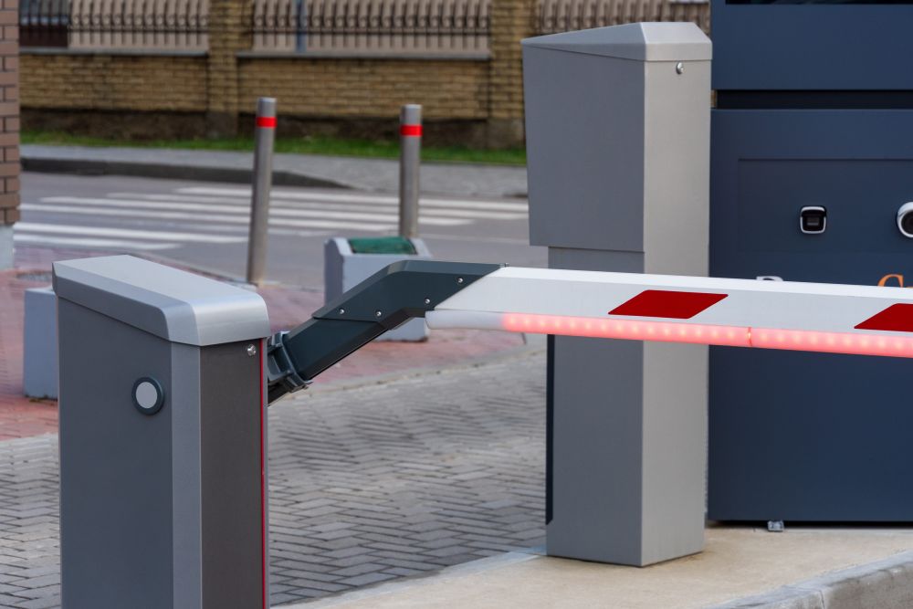 Detalj automatske parking rampe sa motornim kućištem, zglobnim mehanizmom i crveno-belim krakom sa LED osvetljenjem